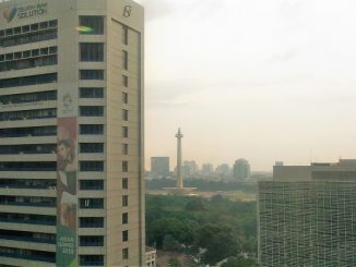 Monumen Nasional (Monas) terlihat di kejauhan dari gedung bertingkat di Jakarta