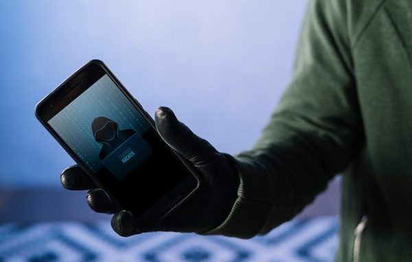 Hacker dengan ponsel Hacker dengan ponsel di tangan