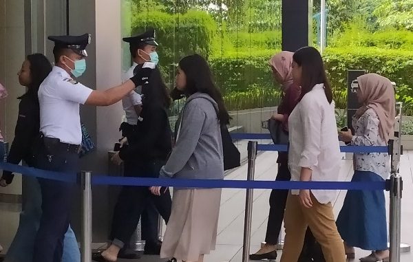 Petugas memeriksa dengan alat thermo scanner di sejumlah pintu masuk perkantoran yang ada di Sudirman Central Business District atau SCBD di Jakarta Selatan, Rabu, 11 Maret 2020