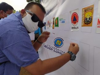 Humas Universitas Budi Luhur menempelkan logo Universitas Budi Luhur dalam Deklarasi Komitmen Dukungan Pentahelix dalam Penanganan Covid-19 di TPU Pondok Rangon yang diinisiasi oleh Badan Nasional Penanggulangan Bencana (BNPB) pada Minggu, 16 Agustus 2020