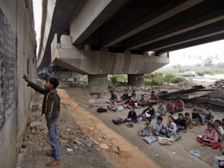 Guru mengajar anak-anak miskin di bawah jembatan di New Delhi