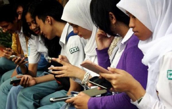 Siswa SMA dengan smartphone di tangan