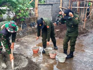 Dua mahasiswi UTY sedang membantu mencampur semen untuk pembangunan pos RW