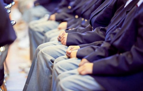 Male students sitting in a row at the school ceremony hall