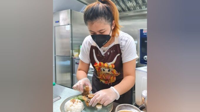 Rachel Rachel, mahasiswi asal Bogor, bekerja di kedai sop buntut yang dia kelola di Singapura. (8days.sg)