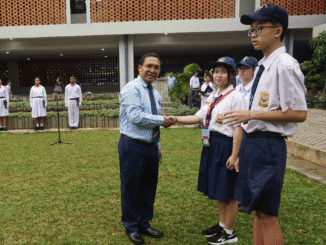 Penyematan tanda peserta MPLS pada siswa baru oleh Kepala Sekolah SMA Tarakanita 2 Jakarta, Yosef Todarung S.S. M.M.