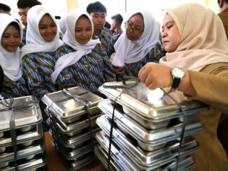 Guru sedang membagikan menu MBG di sekolah. (Ist.)