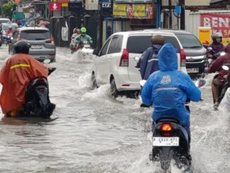 Kendaraan mogok saat melintasi jalanan yang tergenang banjir di dekat Perumahan Jatibening Permai